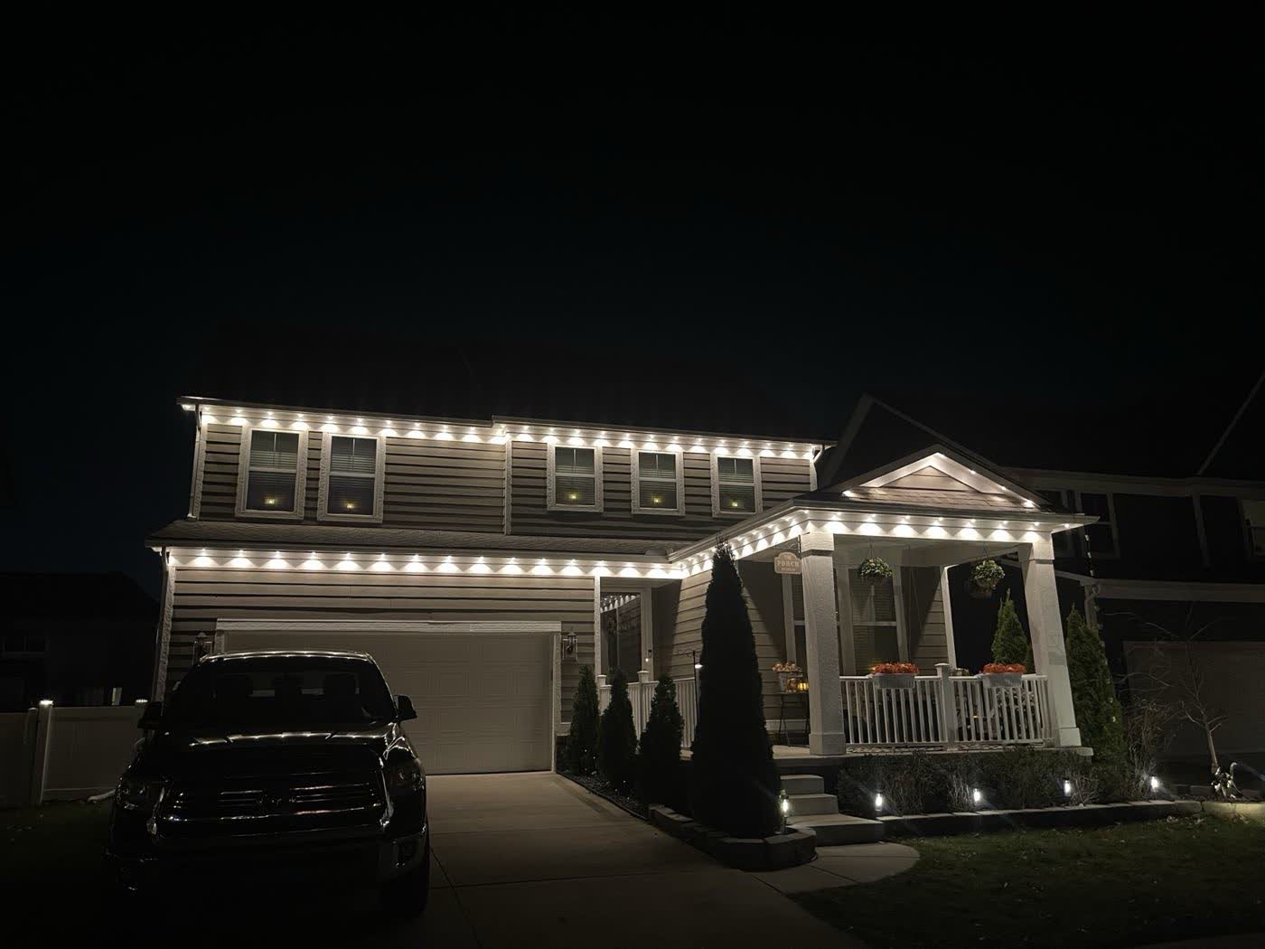 Warm white holiday roofline lighting on a two-story home
