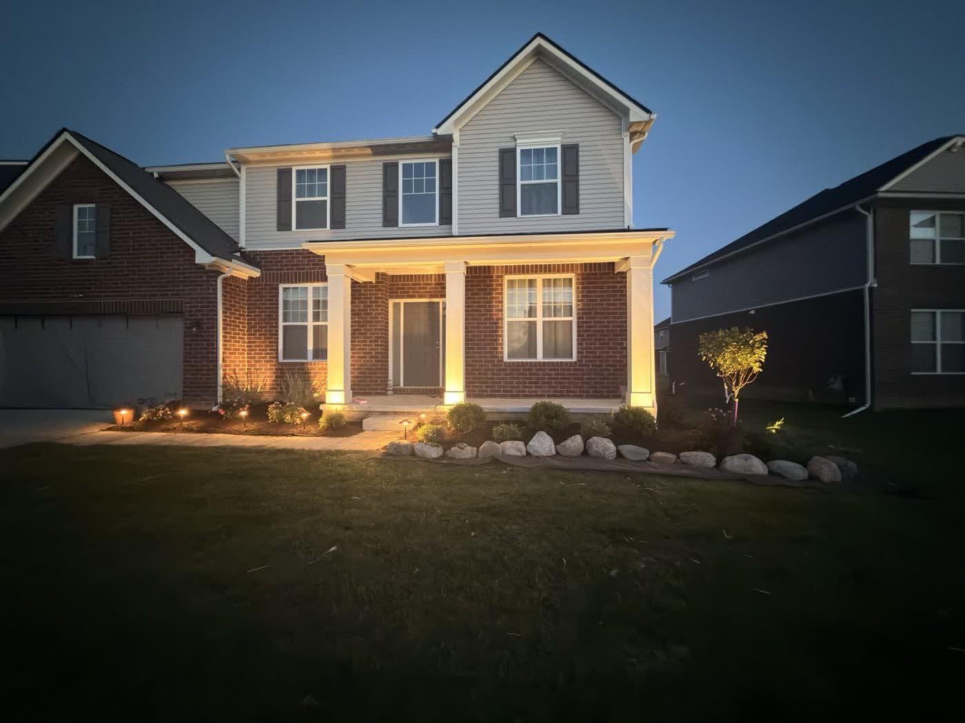 Low-voltage landscape lighting at dusk with uplit porch columns
