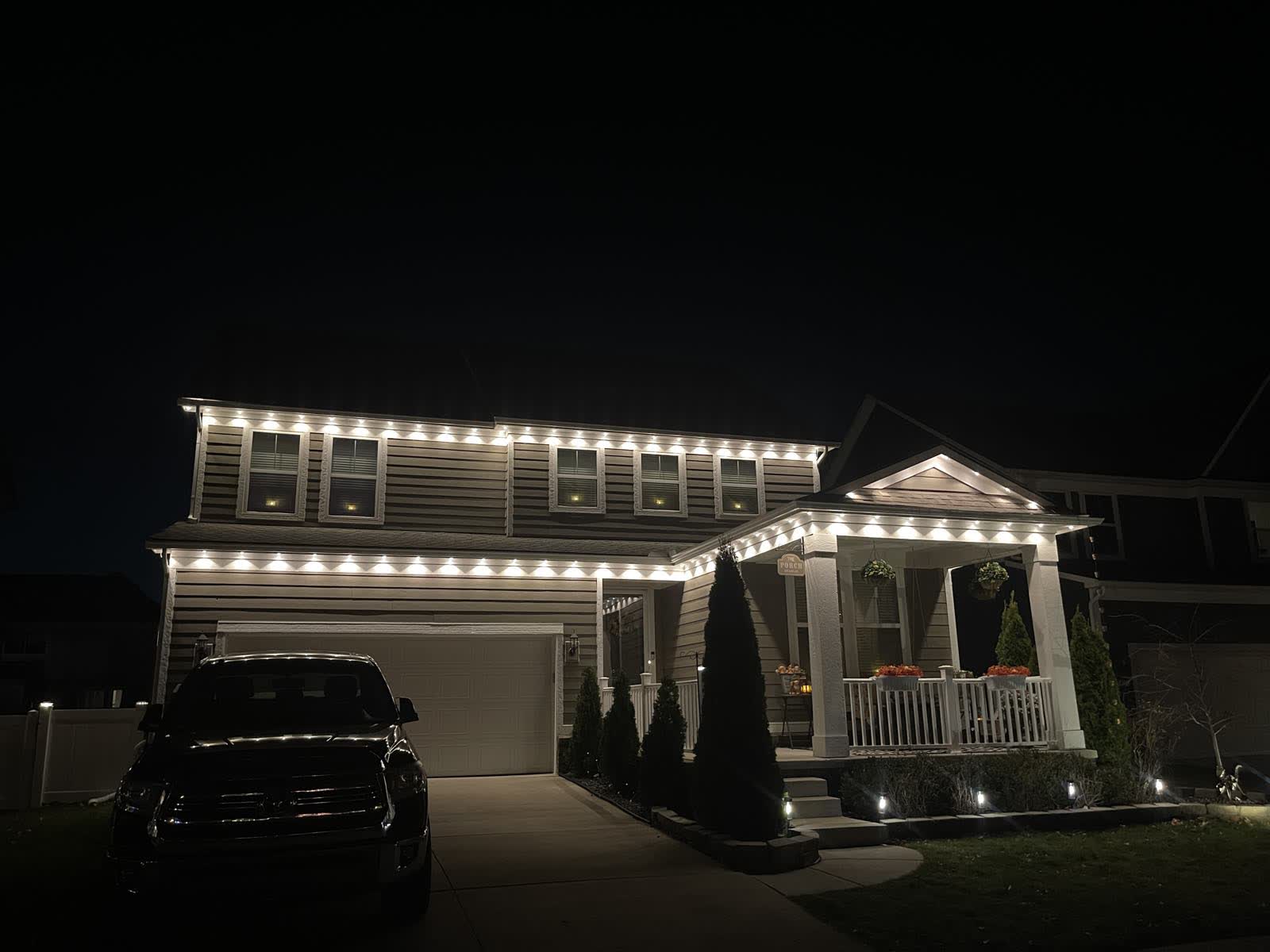 Finished: the full roofline lit end to end in even warm white holiday lighting
