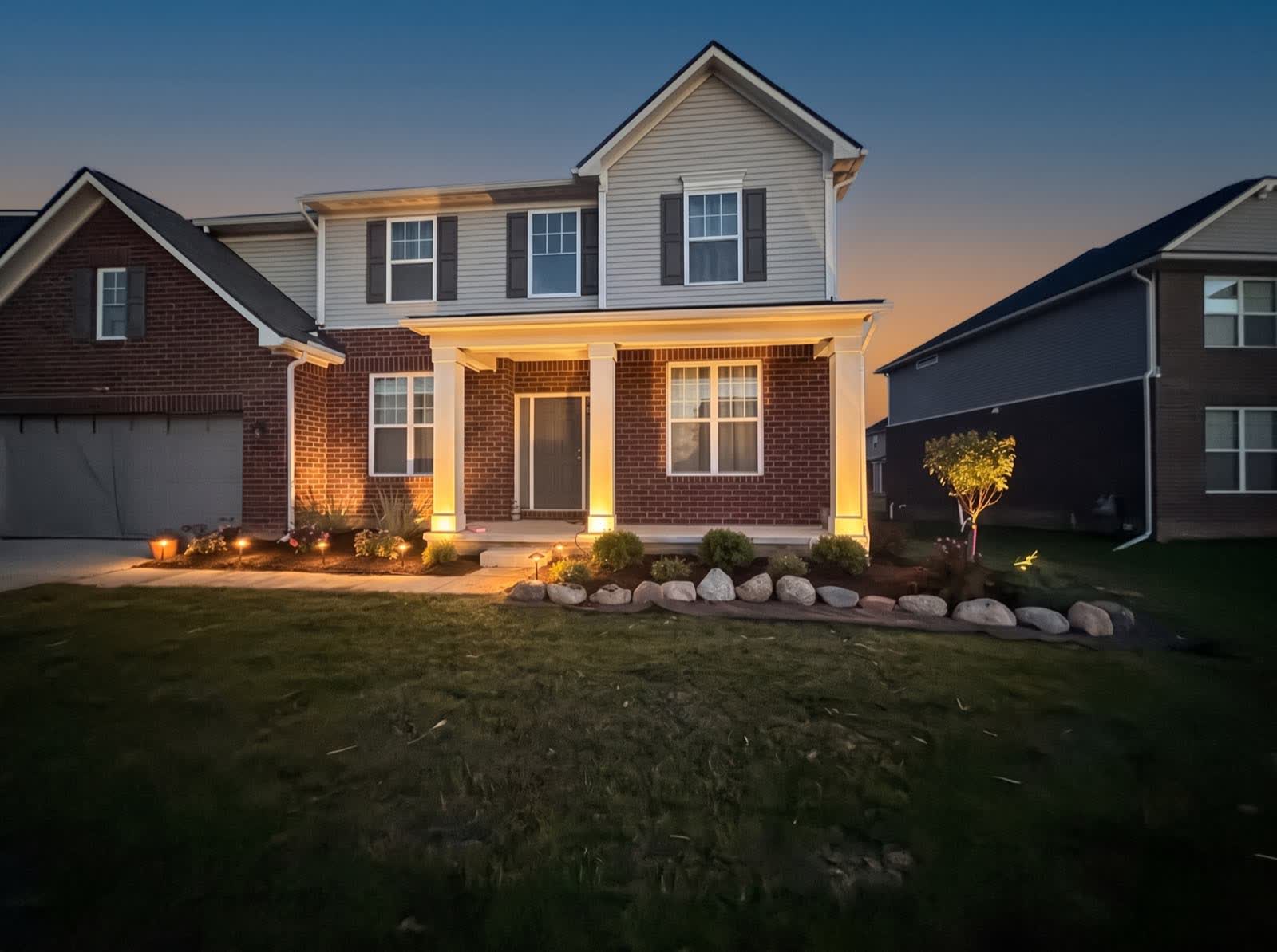 Dusk: the low-voltage uplights and path lights switching on against the last of the daylight