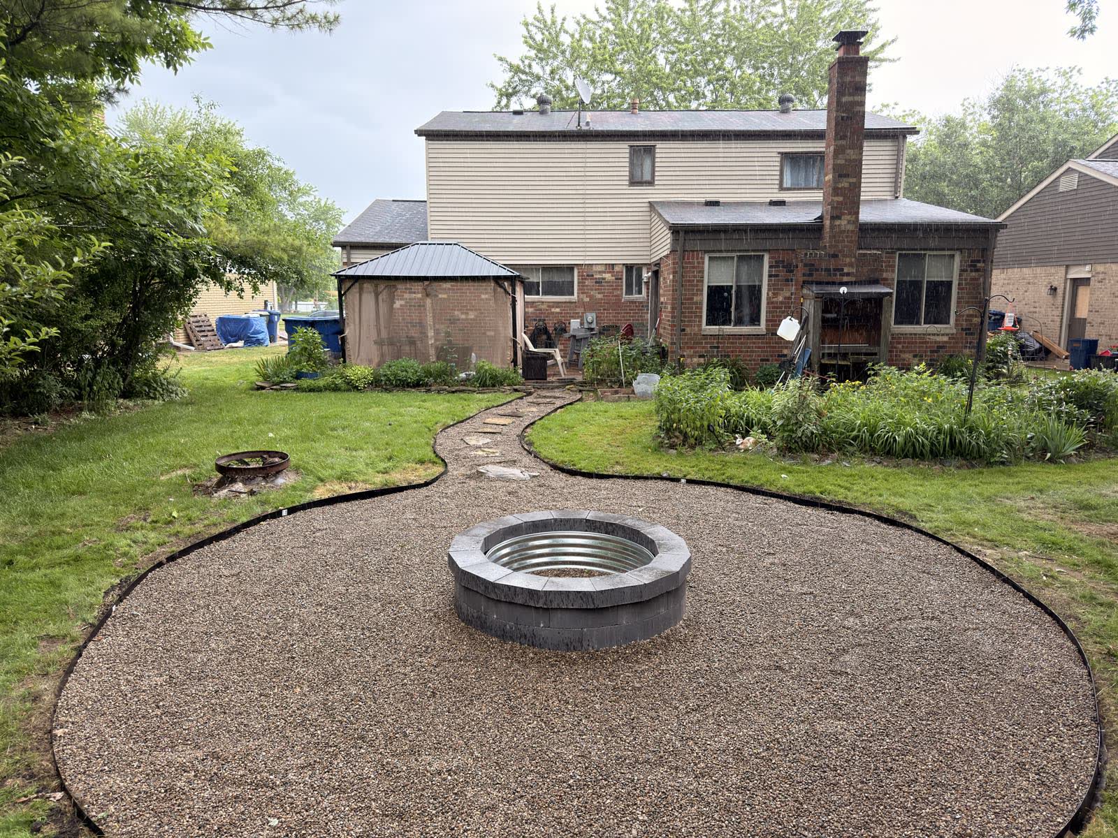 Finished: a pea-gravel patio with a cut-stone fire pit ring and clean edging